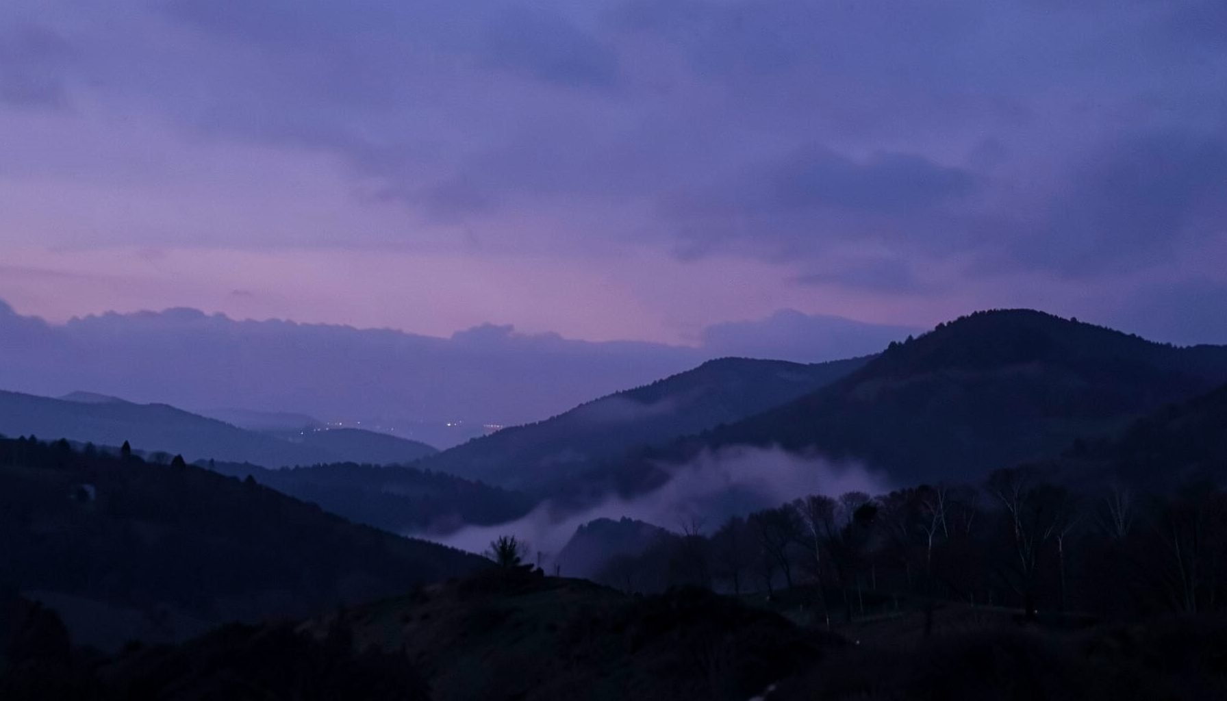 A dreamy, dusky landscape with soft purple and navy tones, evoking a quiet evening mood
